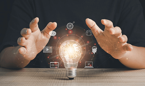 Inovação em estratégias digitais para websites de alto desempenho Mãos envolvendo uma lâmpada com cérebro iluminado e ícones digitais representando estratégias digitais.